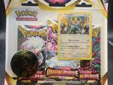 un gros plan sur une boîte de cartes Pokémon avec un pin's