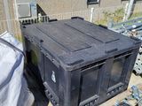 a black box sitting next to a pile of junk