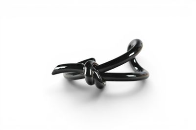 a black ring with a knot on it on a white surface