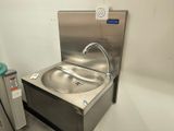 a stainless steel sink and a water dispenser in a room