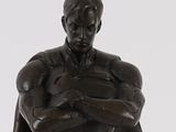 statue of a man with a cape on his shoulders holding a ball