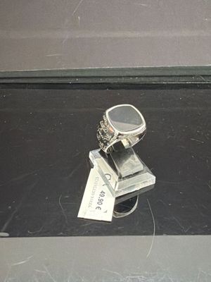 une bague en argent posée sur une pile de livres