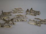 silver plated figurines of various types and sizes on a white surface