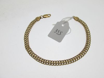 un gros plan sur un bracelet en chaîne dorée muni d'une étiquette de prix
