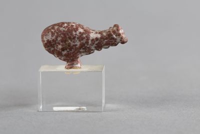 un gros plan d'une figurine représentant un mouton posée sur un socle transparent