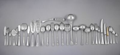 beaucoup d'argenterie sur une table avec des cuillères et des couteaux