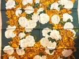 yellow and white roses and leaves on a green and gold scarf