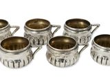 six tasses argentées avec des anses, sur fond blanc