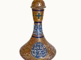 a blue and gold vase sitting on a white surface