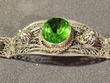 an image of a green stone broochle sitting on top of a table
