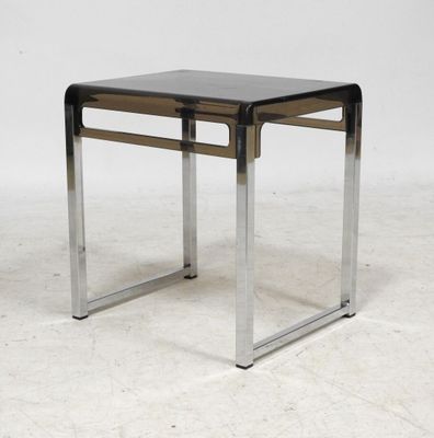 une table d'appoint noire et chromée avec un plateau en verre