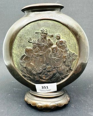un vase en argent orné d'une image représentant un groupe de personnes