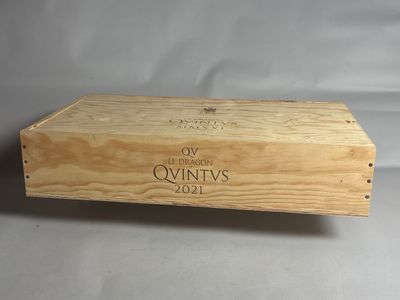 une boîte en bois sur laquelle est collée une étiquette de vin, posée sur une table