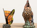 two colorful bird figurines sitting on a wooden table