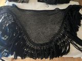 a black crochet purse on a white table