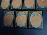 six decks of magic the gathering cards laid out on a table
