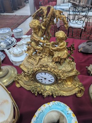 une table sur laquelle se trouvent une horloge dorée et de nombreux autres objets