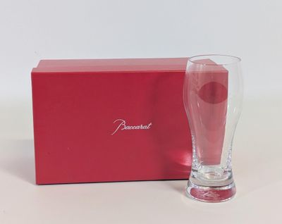 un verre vide à côté d'une boîte rouge posée sur une surface blanche