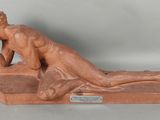 une photo représentant la statue d'un homme allongé sur un banc