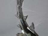 a glass sculpture of a dolphin that is on top of a glass ball