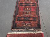 deux tapis rouges et noirs posés sur un sol gris