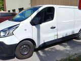 une camionnette blanche garée sur un parking à côté d'un panneau rouge