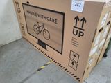 a cardboard box with a bicycle on it sitting on the sidewalk