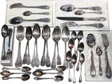a lot of silver spoons and forks in a box