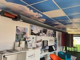 une pièce avec un bureau, des étagères, des chaises et des images au plafond