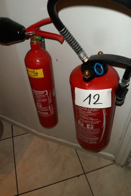 un extincteur fixé au mur à côté des toilettes