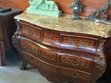 a chest of drawers with statues on top of it in a room