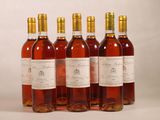 four bottles of wine are lined up on a white surface