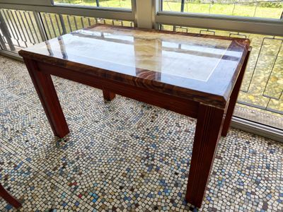 a table with a glass top on a tiled floor