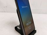 a close up of a phone on a stand with the welcome screen open
