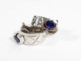 pair of silver rings with blue stones sitting on top of each other