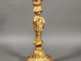 an image of a gold candle holder with a bird on top