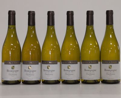 six bottles of white wine lined up in a row on a table