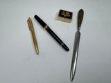 un stylo, un crayon et un timbre posés sur une table