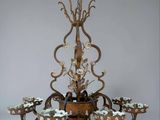 a chandelier made of wood and metal with flowers and leaves