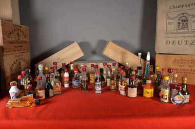 many bottles of alcohol sitting on a table with a red table cloth