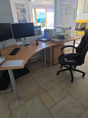 un bureau avec deux écrans d'ordinateur et une chaise placée devant