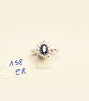a close up of a ring with a blue stone and diamonds