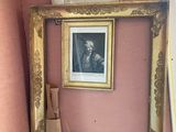 une photo d'une salle de bains avec des toilettes et un tableau accroché au mur