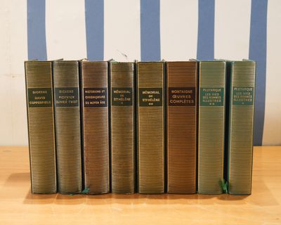 Plusieurs livres sont alignés sur une table en bois