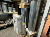 many metal pipes that are stacked up in a warehouse