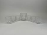 lot de six verres à eau en cristal alignés sur un fond blanc