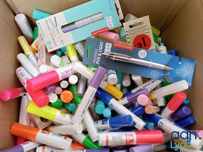 une boîte en carton remplie de feutres et de stylos de différentes couleurs