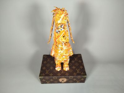 une statue représentant une girafe assise sur une boîte
