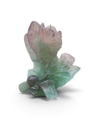 une fleur verte et rose posée sur une surface blanche