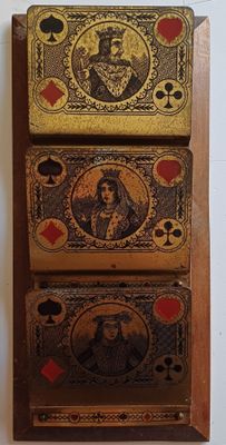 trois cartes à jouer accrochées au mur les unes à côté des autres